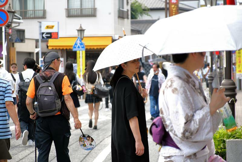 成田祇園祭が開幕した成田山新勝寺の参道では厳しい暑さの中、日傘を差したり、うちわを持ったりして歩く人が目立った＝5日午後、成田市