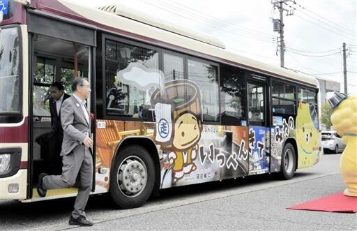 坂井、あわら両市の観光地をPRするラッピングバス=7月25日、福井県あわら市の「あわら湯のまち駅」前