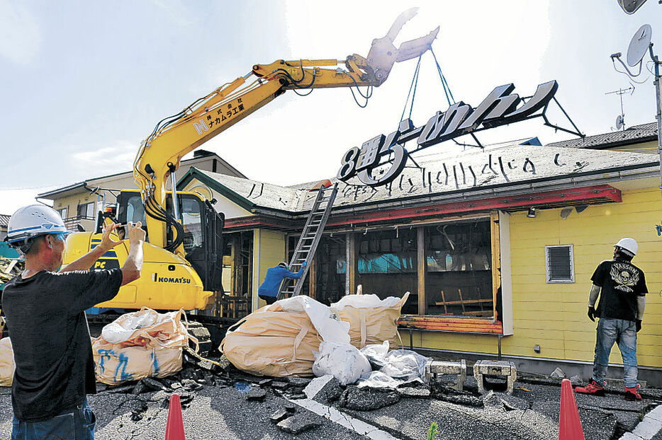 解体作業を見守る山岸さん（左）＝内灘町鶴ケ丘２丁目の「８番らーめん内灘店」