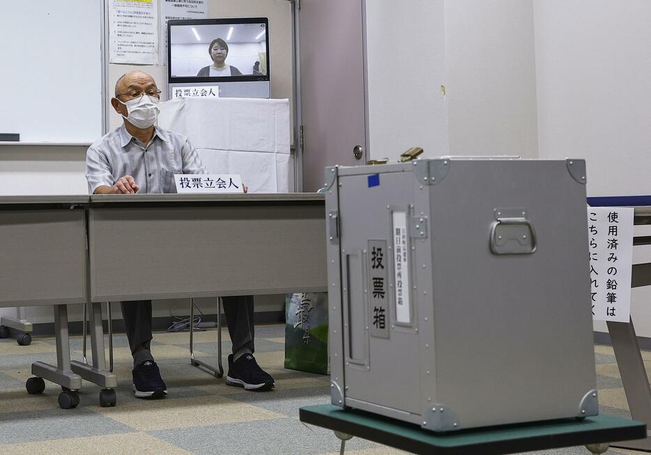 「オンライン立ち会い」が実施された鳥取県江府町長選の期日前投票所。立会人の1人がモニター越しに監視する＝19日午前