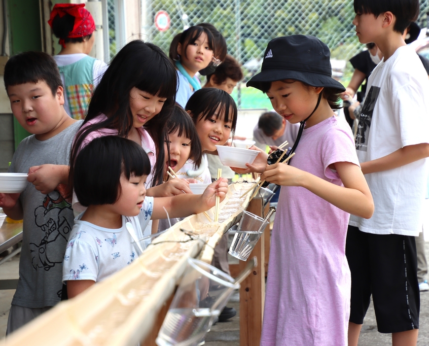 「とれた？」―。「流しそうめん」で夏のひと時を満喫する子どもたち＝2024年7月27日午前11時43分、兵庫県丹波篠山市下原山で