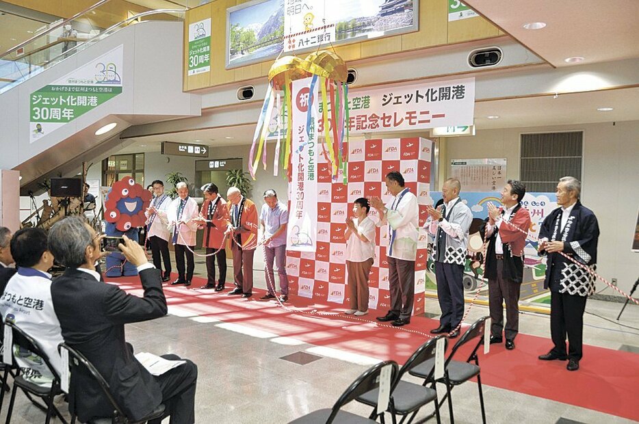 くす玉割りでジェット化開港30周年を祝う関係者