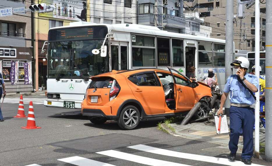 路線バスとガードパイプに衝突した乗用車＝２４日午後２時半ごろ、鹿児島市武１丁目（画像は一部加工してあります）