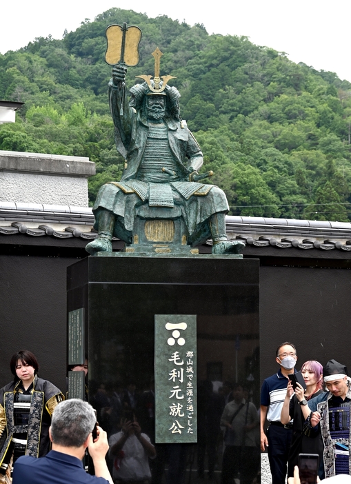 郡山（奥）の麓で除幕された毛利元就の銅像を写真に収める出席者