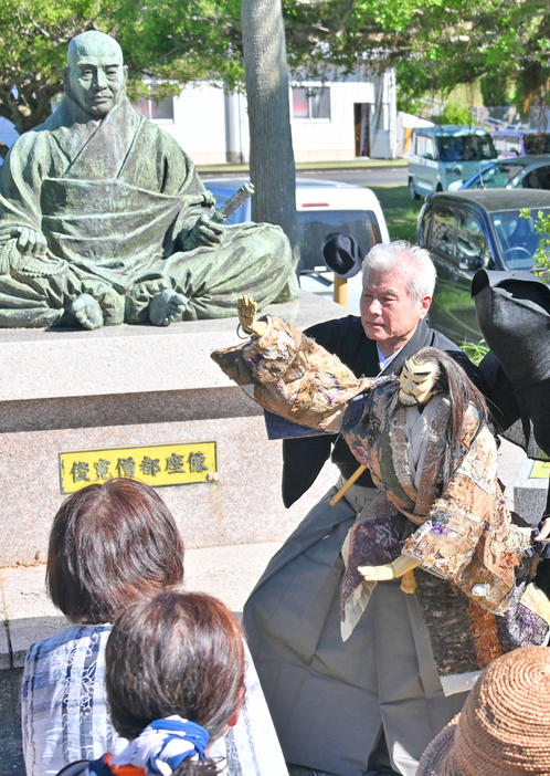 喜界島の「俊寛の像」前で文楽を奉納する人間国宝の吉田玉男さん＝6日、鹿児島県喜界町