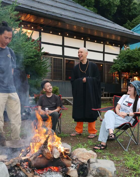 おたき上げを囲んで参加者と話す高津研志さん（右から2人目）