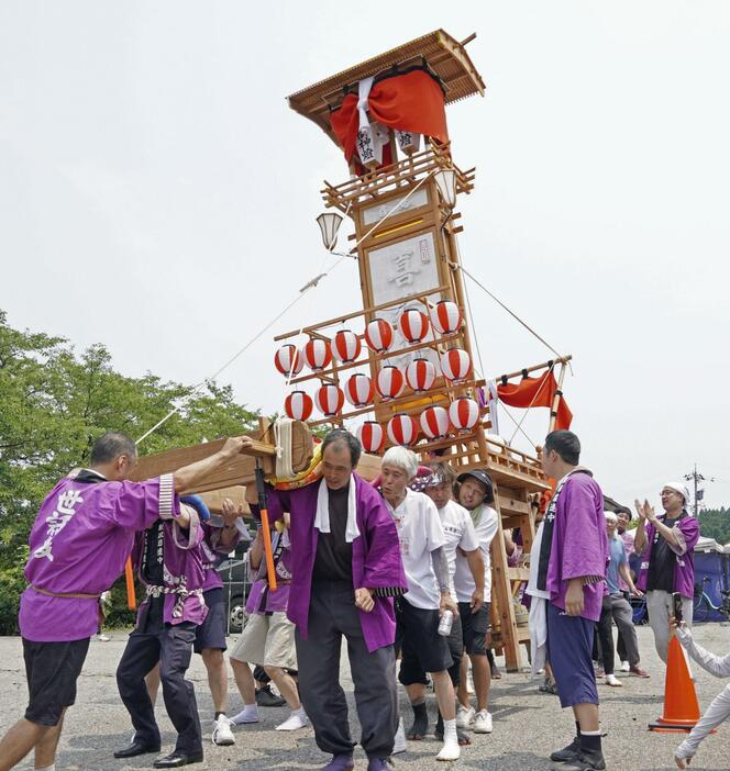 復興祈願のイベントで「キリコ」を担いで祭りを再現する人たち＝13日午前、石川県珠洲市宝立町