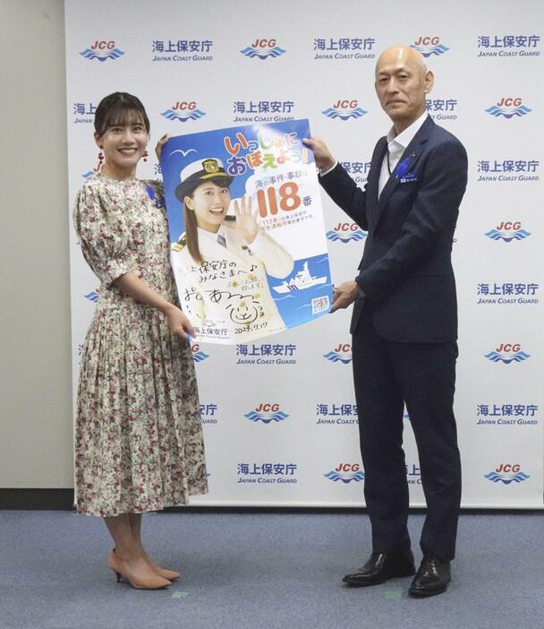 118番の啓発ポスターを報道陣にアピールするタレントの小野あつこさん（左）と海上保安庁の瀬口良夫長官＝17日午後、東京・霞ケ関