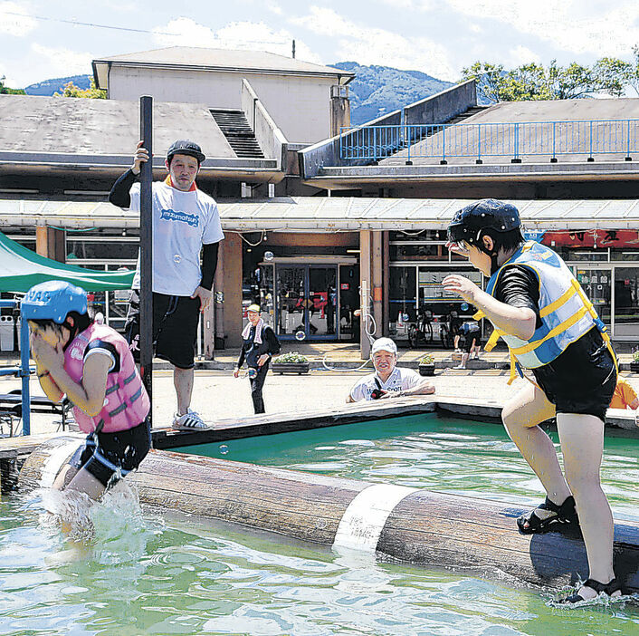 流木乗りを体験する児童＝砺波市の庄川水記念公園