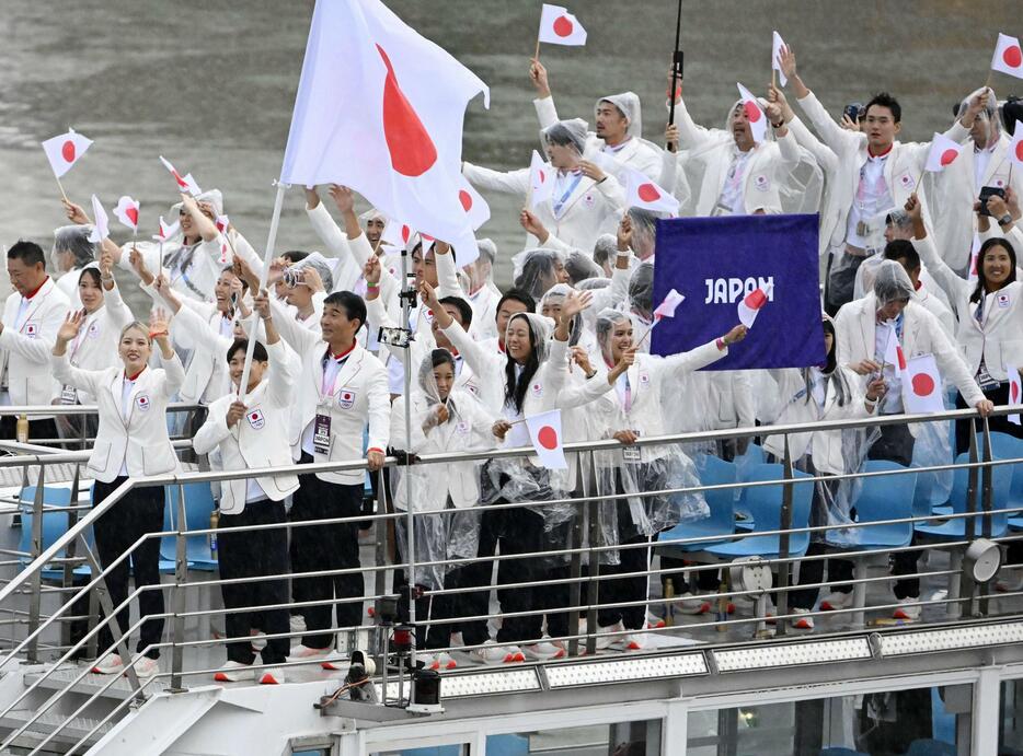 パリ五輪の開会式で、セーヌ川を船でパレードする日本選手団。（手前左から）旗手の江村美咲、半井重幸＝26日、パリ（共同）