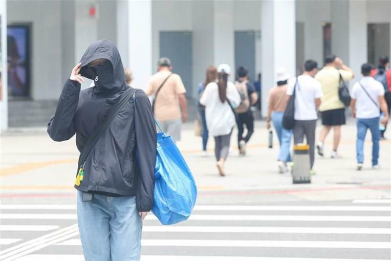 日焼け防止服を着て台北市内の繁華街で横断歩道を渡る人＝資料写真