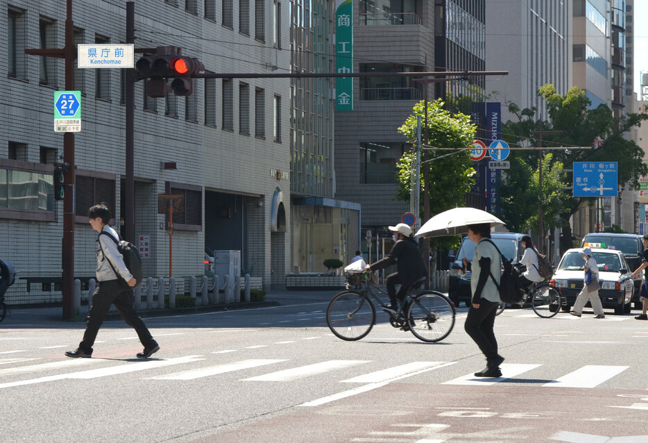 東日本から九州は４日、晴れて気温が上昇し各地で３５度以上の猛暑日を観測した。気象庁によると静岡市は３９．３度と、今夏全国最高を更新する危険な暑さとなった。写真は猛暑の中、横断歩道を渡る人々＝静岡市