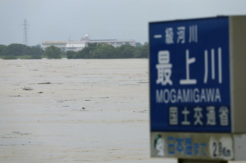 大雨の影響で増水した最上川＝26日午前9時19分、山形県酒田市