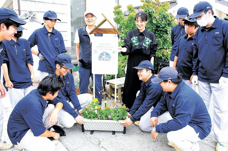 振興組合の事務所前に堆肥を活用した寄せ植えを飾る関係者（10日）