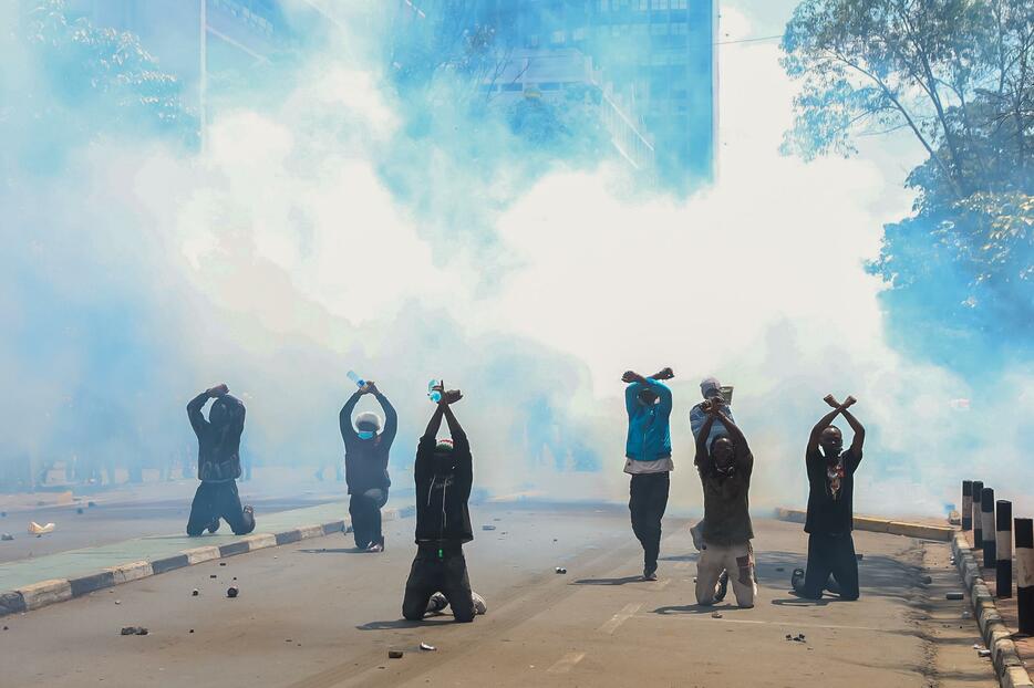 Boniface Muthoni / SOPA Images via Reuters Connect　6月25日、ケニア全土に増税法案反対のデモが拡大。警官隊が催涙スプレーを使用する中、若者たちは腕をクロスさせるジェスチャーで抗議した