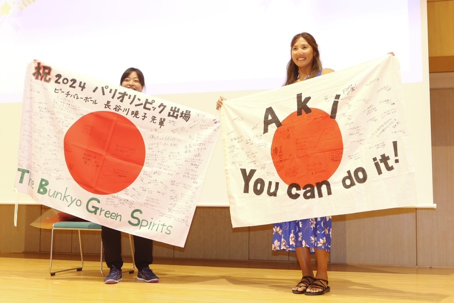 寄せ書きを受け取った長谷川は（右）は笑顔を見せる