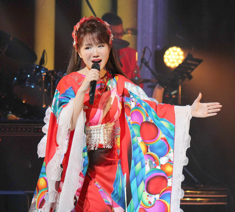 新曲「苺」に合わせ赤い着物姿で歌う大沢桃子