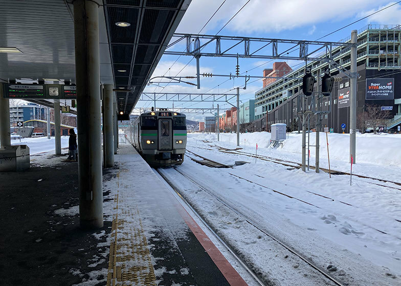 JR小樽築港駅で快速電車を待つ。右手には超大型ショッピングセンター「ウイングベイ小樽」の姿がチラリと見えます（写真撮影／永見 薫）