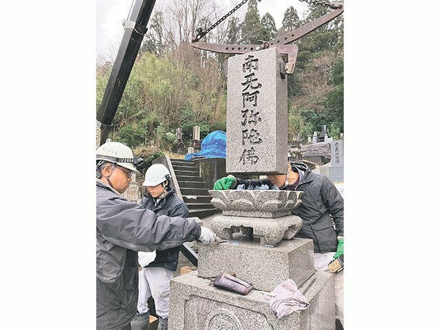 地震で被害を受けた墓石の修復作業をする山岡石材工業の職人 ＝１月中旬、氷見市内