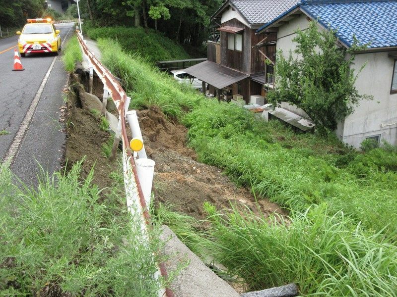 のり面が崩れた県道鷲羽山公園線。民家の敷地に土砂が流れ込んだ＝11日午前10時21分、倉敷市菰池