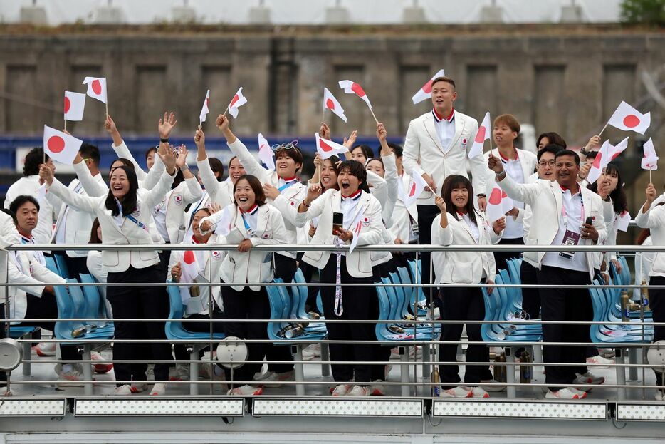 パリ五輪開会式で、セーヌ川河畔の観客の声援に応える日本選手団＝2024年7月26日、パリ（ロイター）