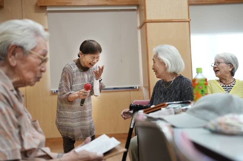 戸山ハイツのシニア館で他のメンバーと談笑する遠藤さん（左から２人目）。笑顔がはじけた