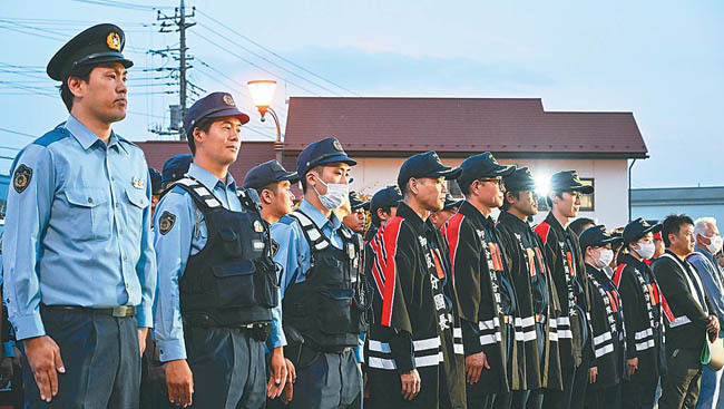 果実の盗難防止パトロールには警察やJAなどの防犯団体が多く参加。24時間体制の警戒は果実の収穫が終わる9月末まで続く（山梨県笛吹市で）