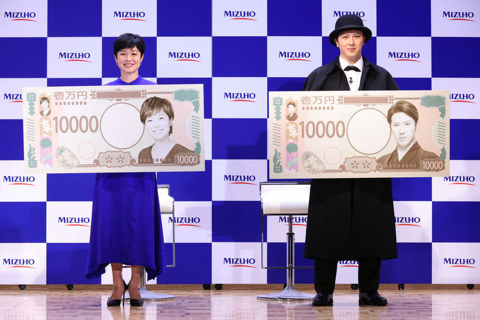 ともに自身が肖像になった特大1万円札を手にする尾上松也（右）と有働由美子