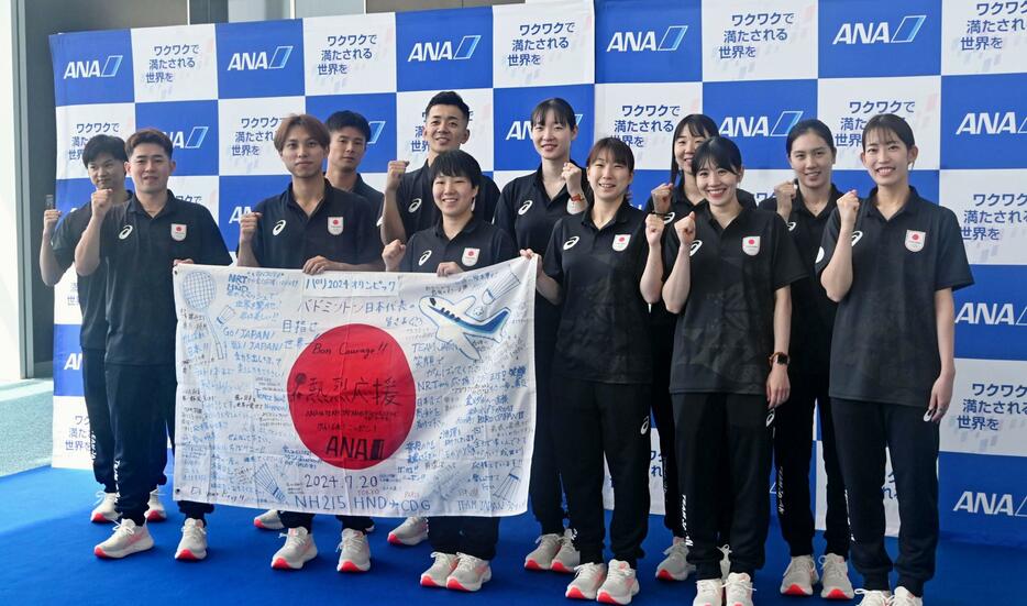 出国前に写真撮影に応じるバドミントンのパリ五輪日本代表選手たち＝20日、羽田空港