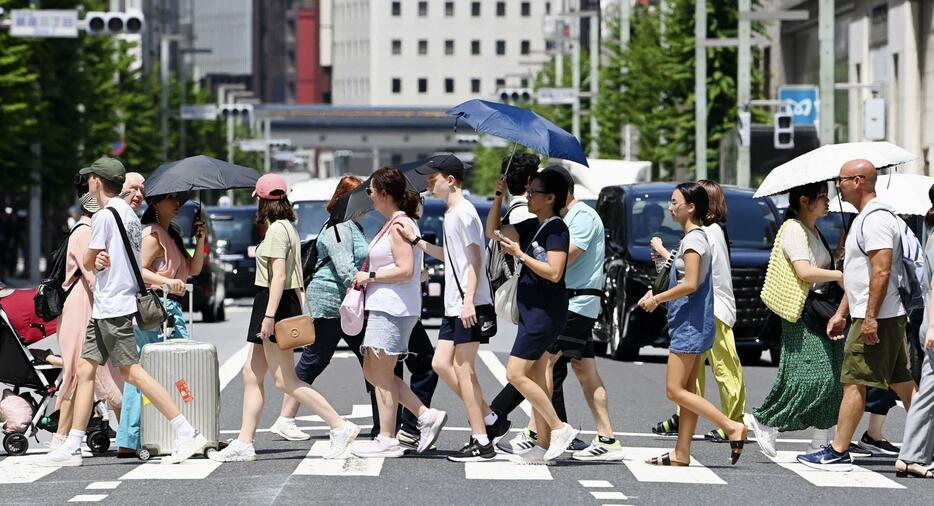 暑さの中、東京・銀座を行き交う人たち＝3日