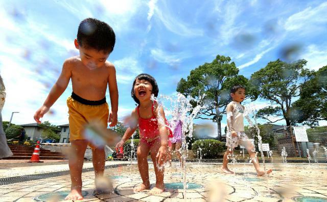 梅雨明けした県内。青空の下、笑顔で水遊びする子どもたち＝１７日午前、宮崎市・大坪池公園