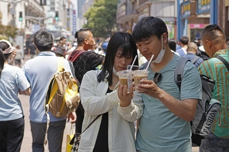 南京市の街でアイスコーヒーを飲む人たち（2023年5月1日撮影、資料写真）。