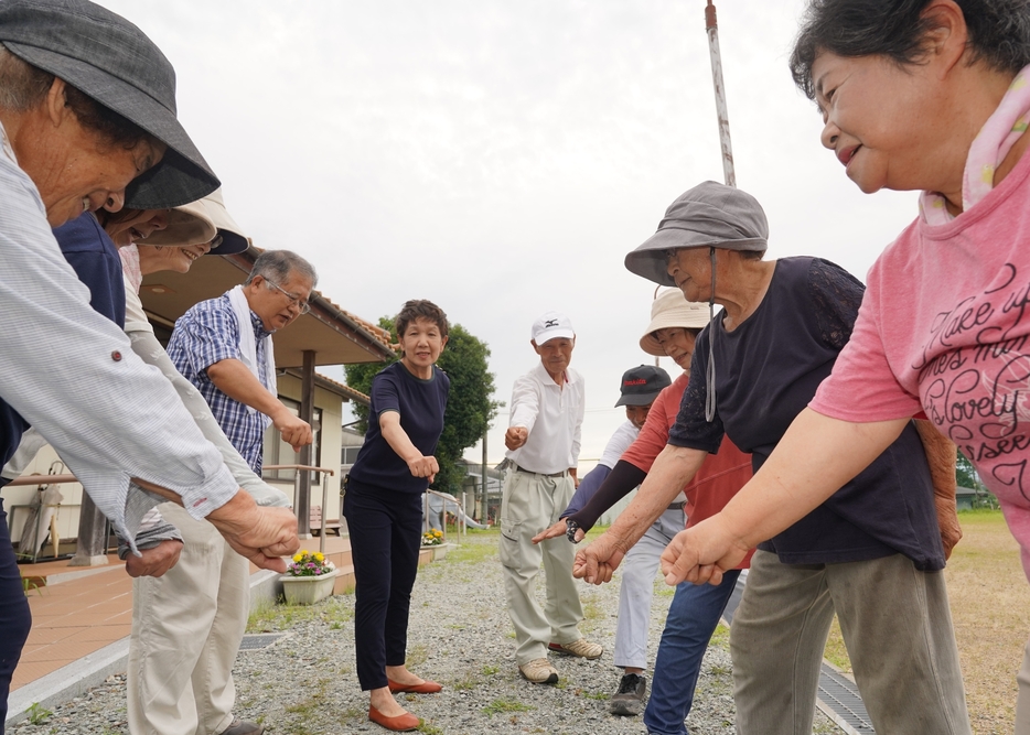 「きょうも一日、頑張ろう」「おーっ」。ラジオ体操の後、円陣を組んで気合を入れる住民たち