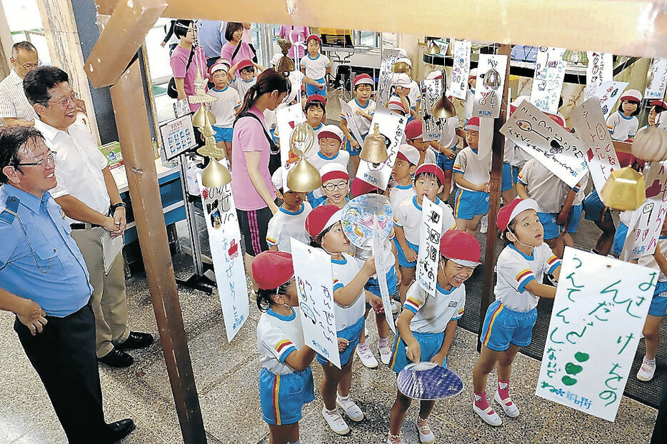 設置した風鈴をうちわであおぐ園児＝高岡署