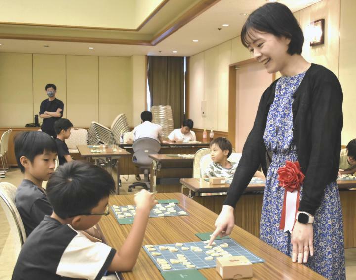 山根女流三段（右）の指導対局を受ける児童たち