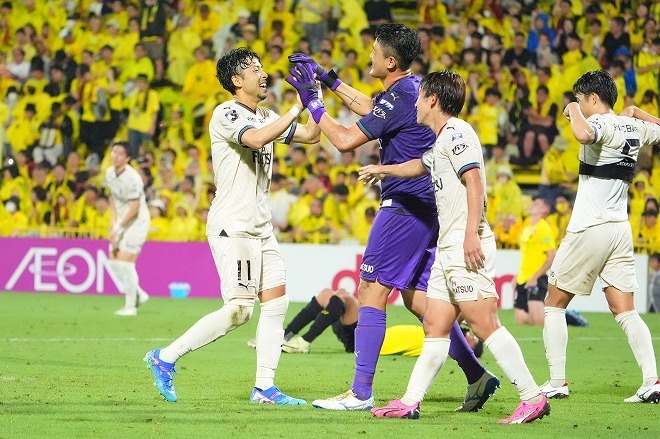 小林（写真左）とGKチョン・ソンリョンが勝利を喜ぶ。PKのピンチをしのいだ。写真：田中研治（サッカーダイジェスト写真部）