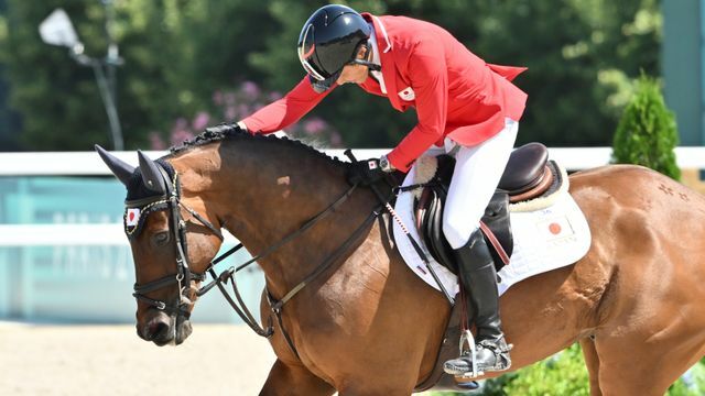 馬術の大岩義明選手が競技終わって馬をねぎらう(写真：エンリコ/アフロスポーツ)