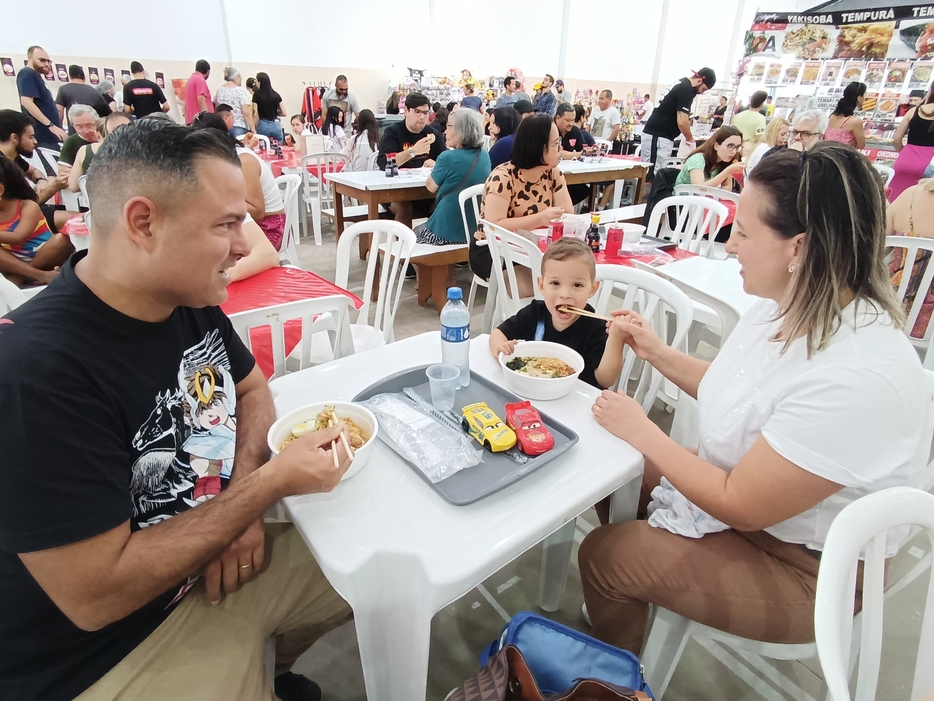 会場でラーメンを食べるブラジル人親子