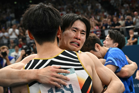 パリ五輪、体操男子団体決勝。優勝してチームメートと喜ぶ萱和磨（2024年7月29日撮影）。