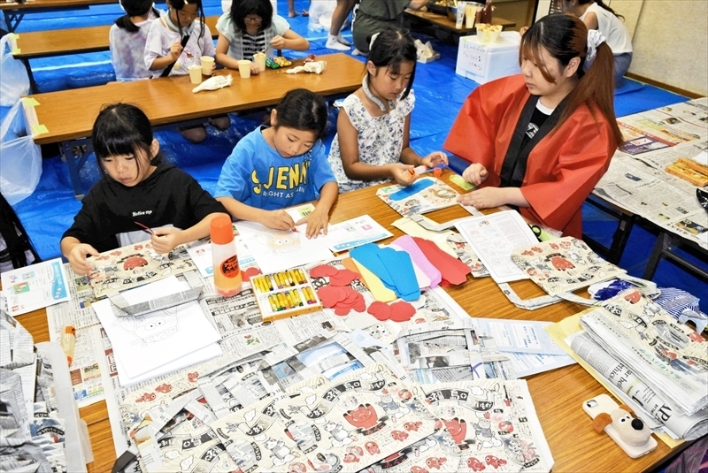 学生らと新聞紙バッグ作りなどを楽しむ子どもたち