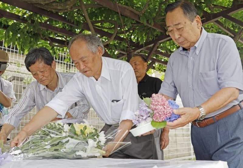 犠牲者が出た寮跡地に設置した献花台に花を供える地元町会の会長ら＝２０２４年６月、長野県松本市