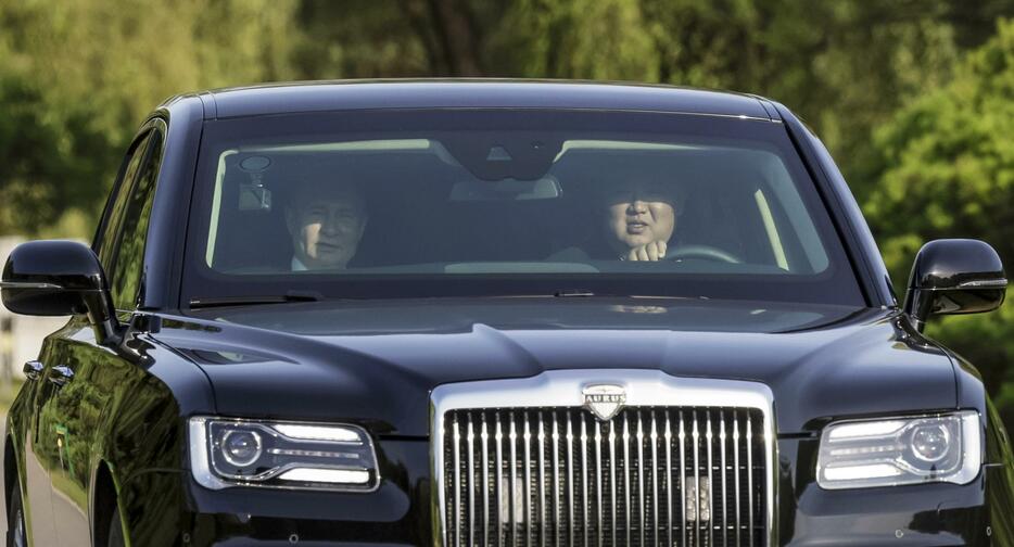 ロシアのプーチン大統領（左）を乗せ、車を運転する北朝鮮の金正恩朝鮮労働党総書記＝6月、平壌（スプートニク提供、AP＝共同）