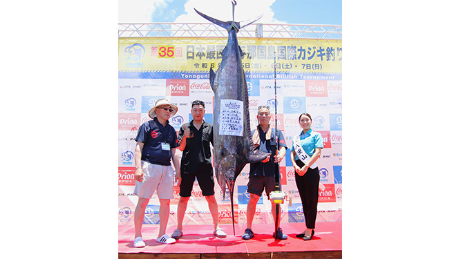 釣り上げたカジキと記念撮影した田中さん（写真中央右）＝6日、久部良漁港