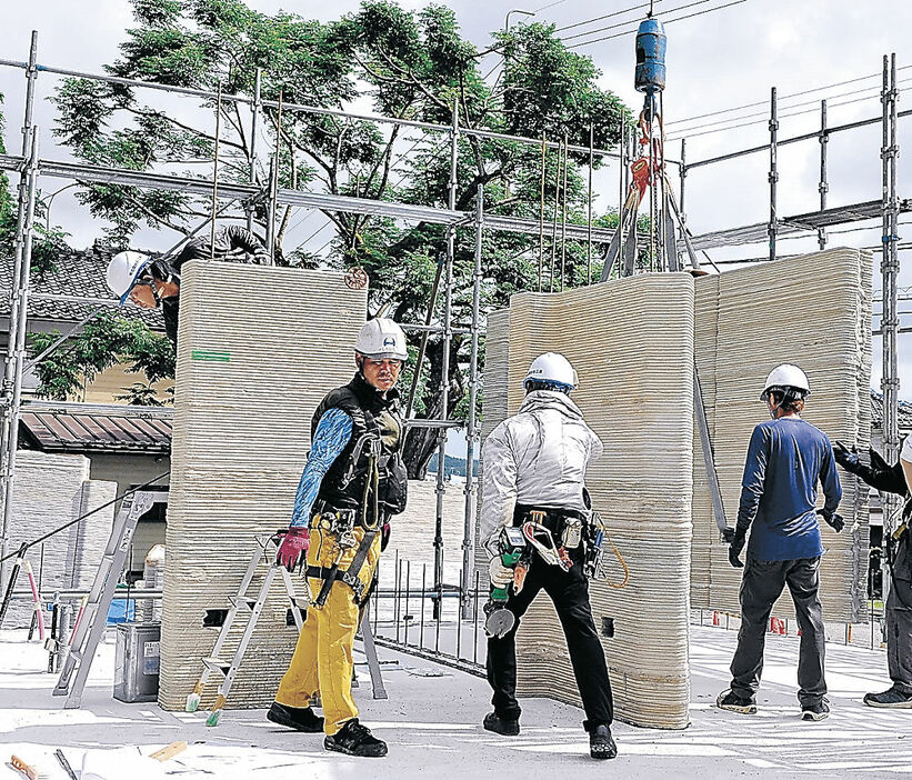 ３Ｄプリンターで作られたパーツを組み上げる作業員＝２２日午前８時５５分、珠洲市上戸町南方