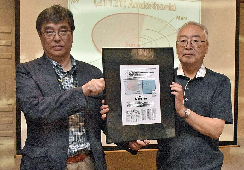 小惑星を発見、命名した渡辺さん（左）から額を受け取る安藤昌益資料館館長の三浦さん＝6月22日