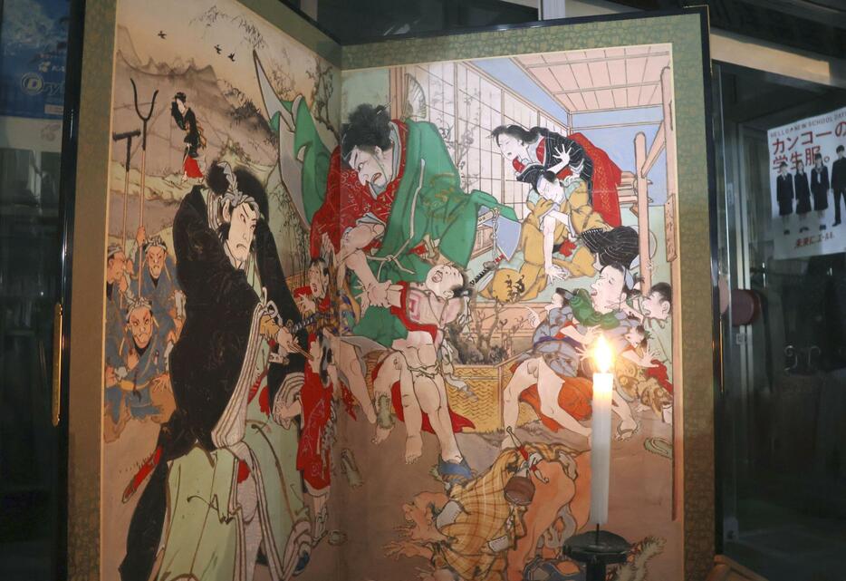 「土佐赤岡絵金祭り」で商店街の軒先に展示されたびょうぶ絵＝20日夜、高知県香南市