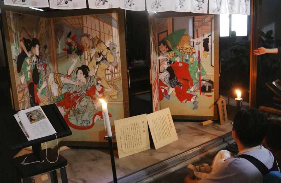 「土佐赤岡絵金祭り」で商店街の軒先に展示されたびょうぶ絵＝20日夜、高知県香南市