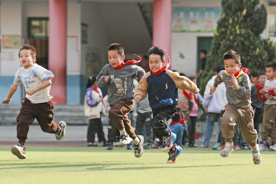 グラウンドを走る小学生＝3月、中国貴州省（共同）