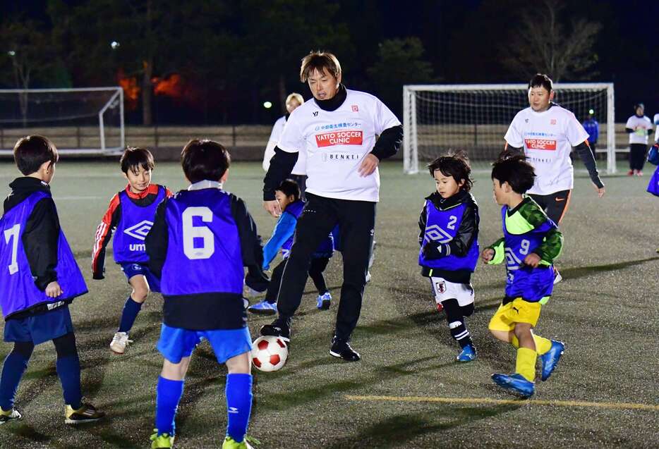 子どもたちとミニゲームをする遠藤保仁さん＝鹿児島市の県立サッカー・ラグビー場