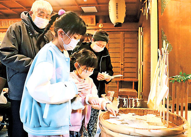 罪や汚れを移した形代をたるに浮かべる参拝者=射水神社